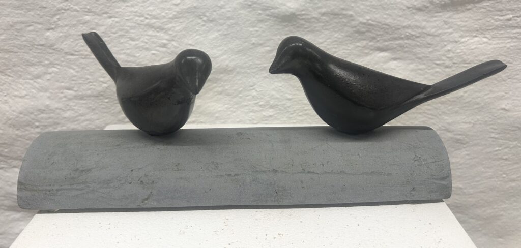 Sculpture représentant deux oiseaux noirs posés côte à côte